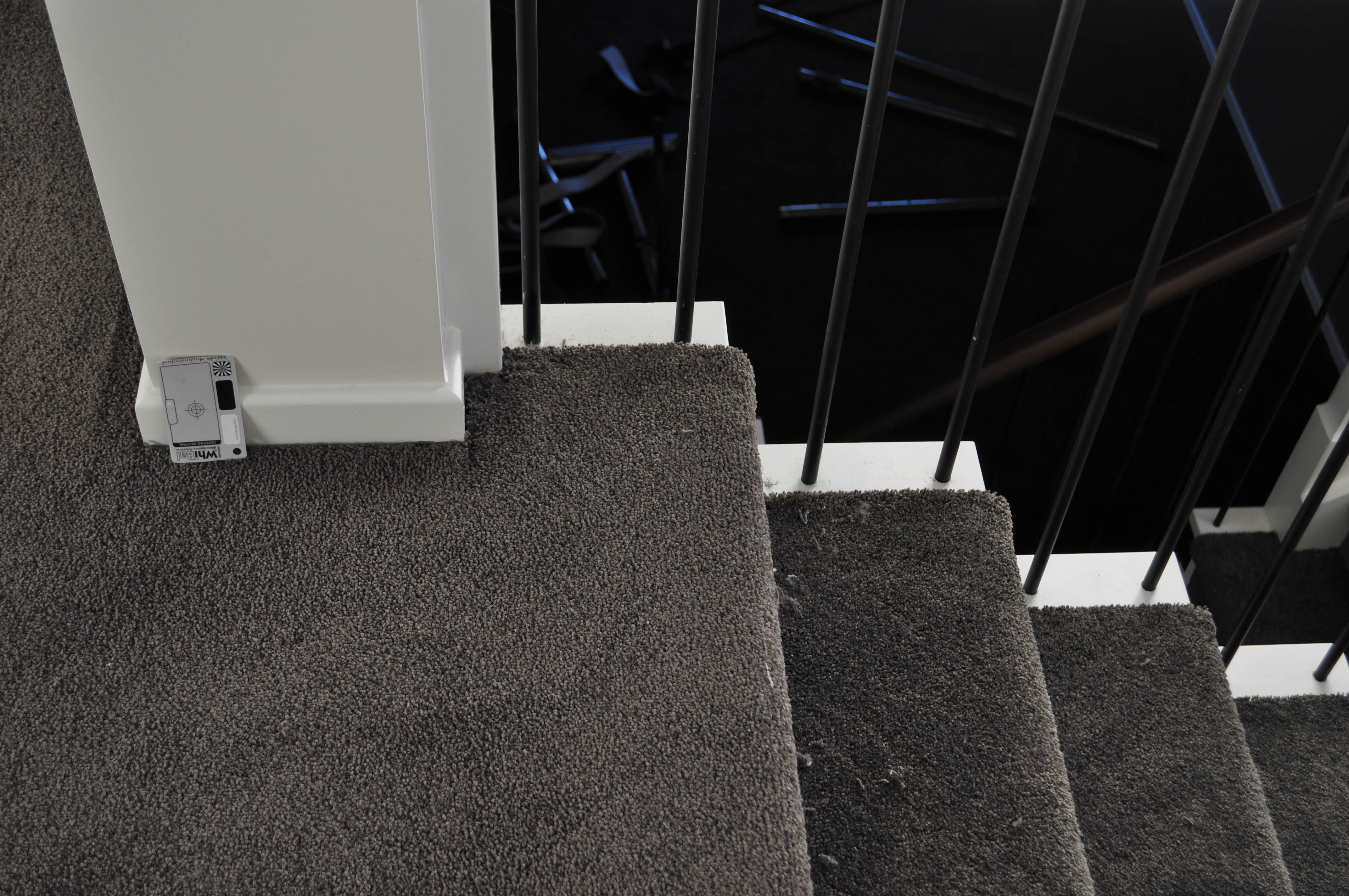 showing a staircase that is carpeted, the carpet being of a  brown color, twist pile, nylon yarn carpet.