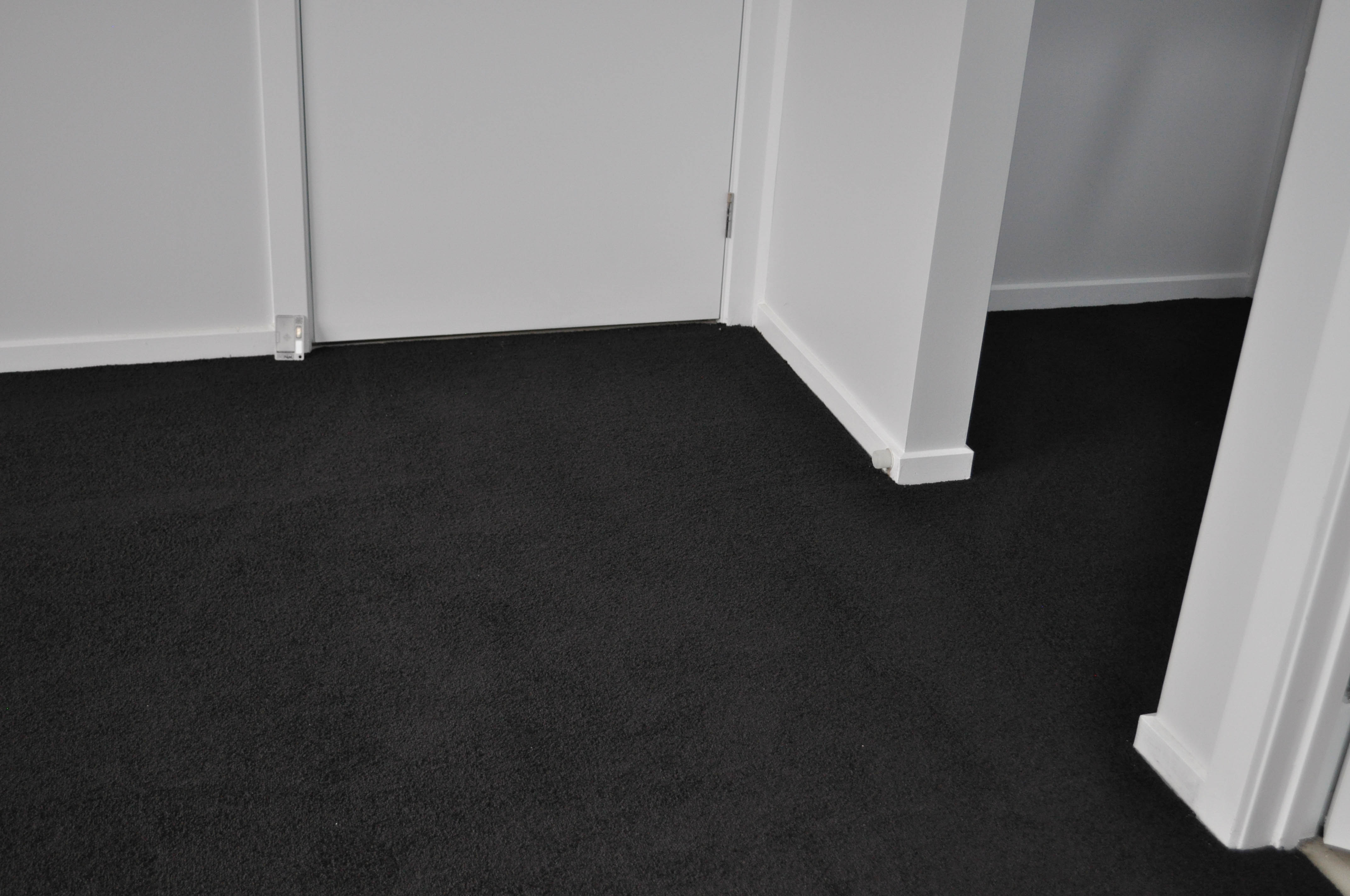 showing a room in a Derrimut house, and it's floor carpeted by a, black coloured plush pile, nylon yarn carpet, installed by Concord Floors.