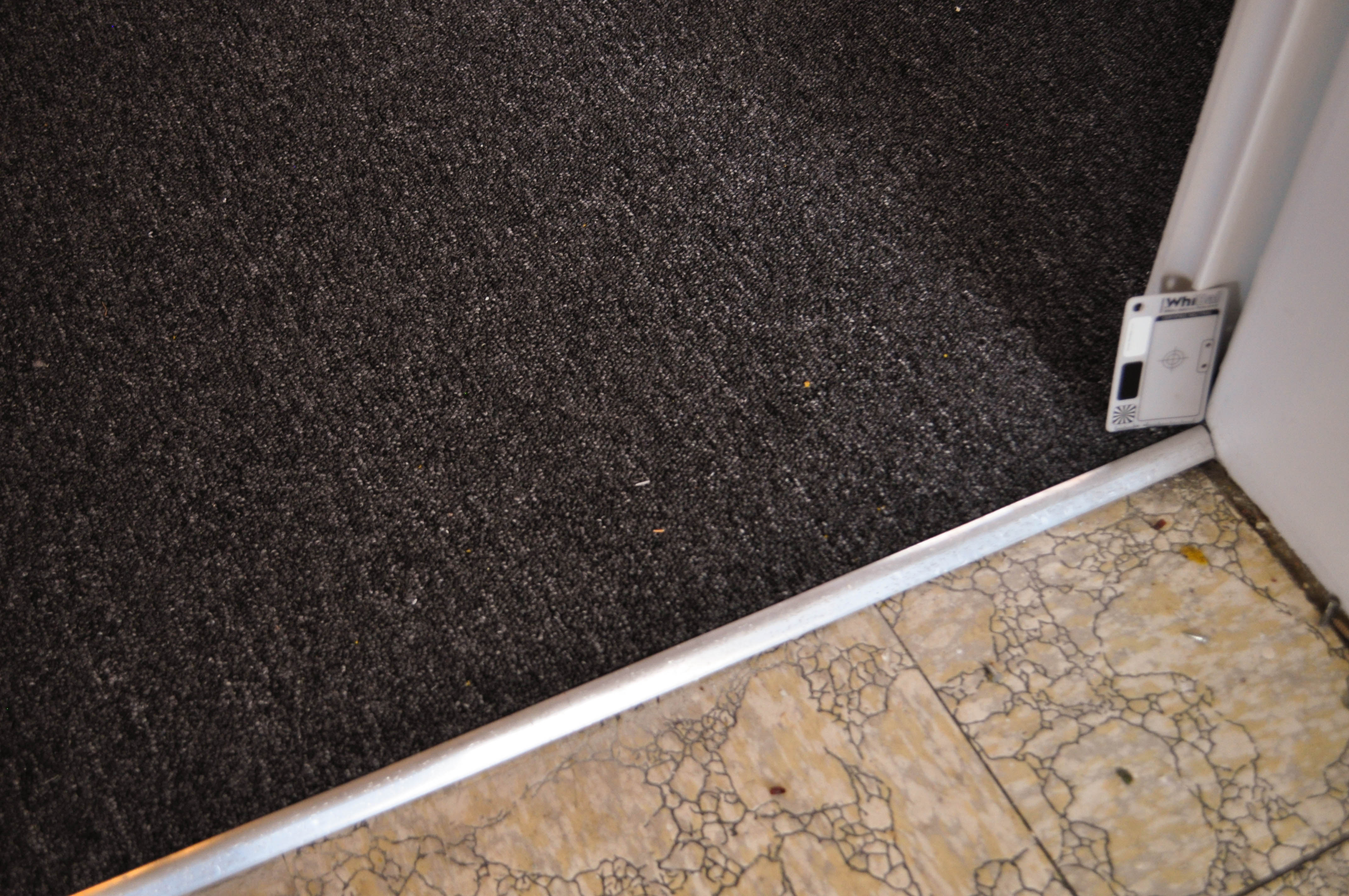 showing a black coloured carpet on a room's floor, it being a loop pile, polypropelene yarn carpet on sale at Concord Floors.