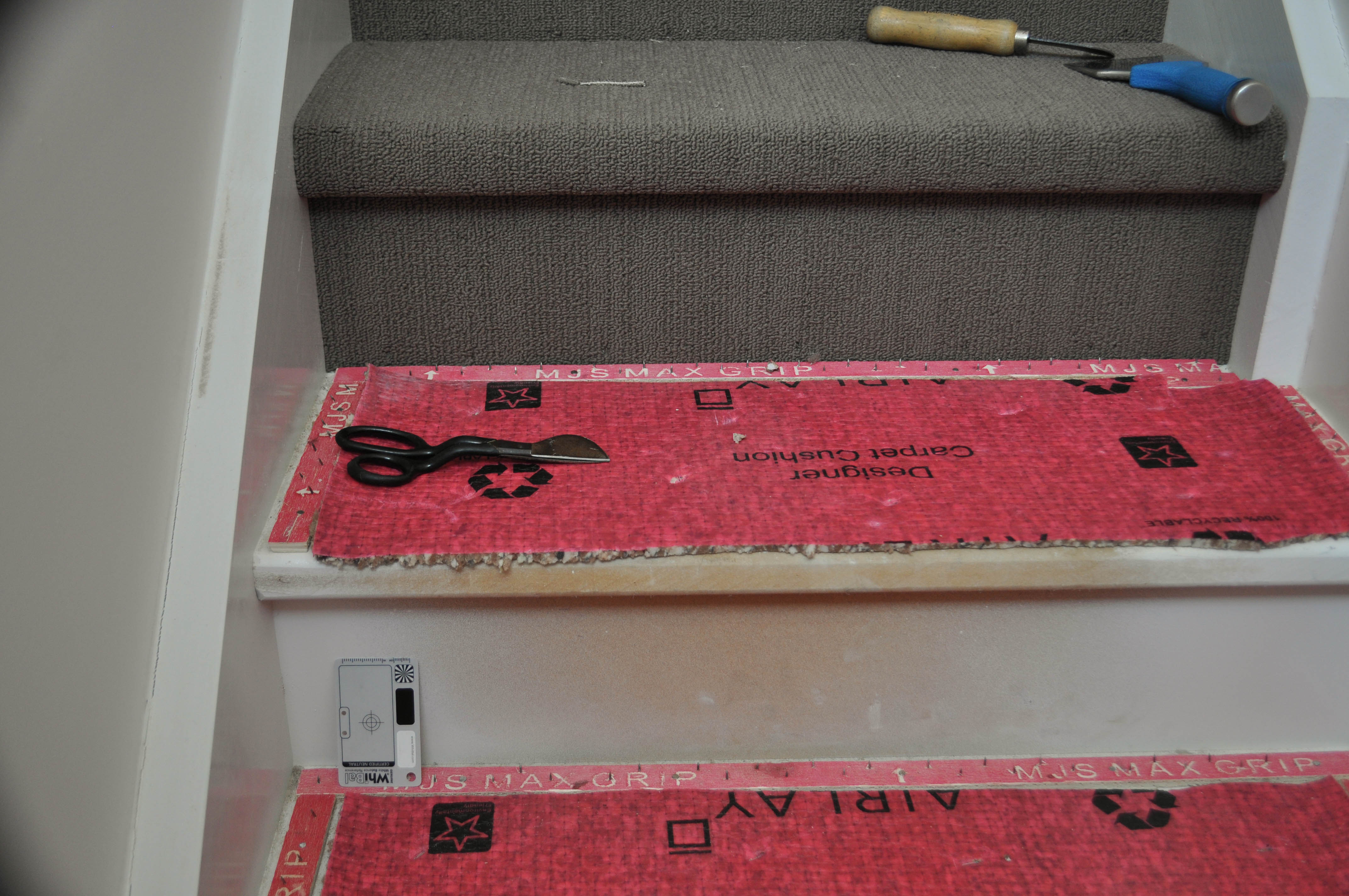 showing two steps. One has installed gripper around the step tread in a staircase and installed underlay. The other has the carpet fully installed. 
	  Work by Concord Floors, in a house Point Cook, Werribee, Vic 3030, Concord Floors.