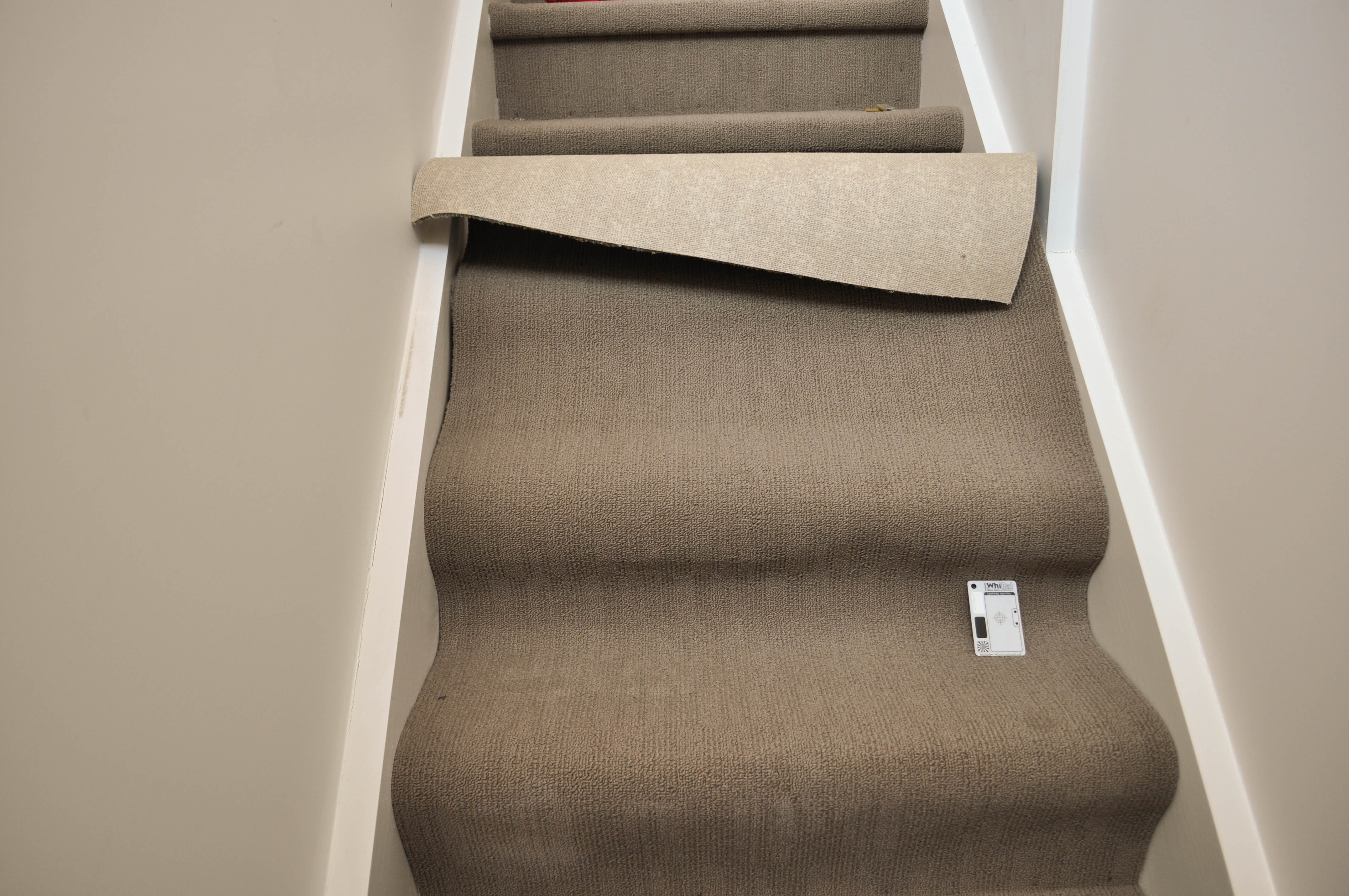 The slab of carpet that has been cut to size and positioned on the staircase and bottomed has been
  stapled with an electric tacker to stay permanently in place.