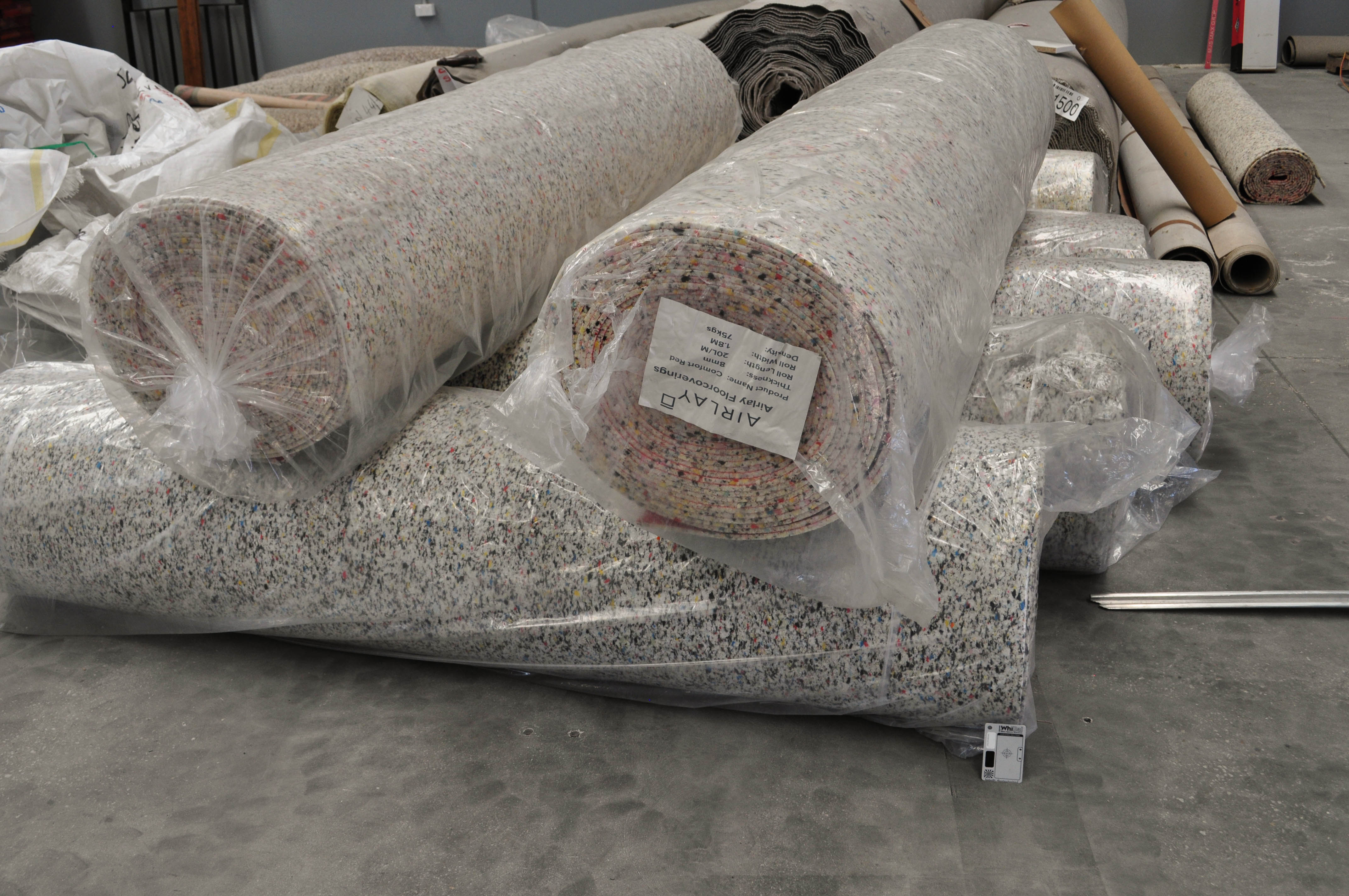 showing stacked rolls of carpet underlay in the concord Floor's warehouse. This carpet is for sale to the
 public.