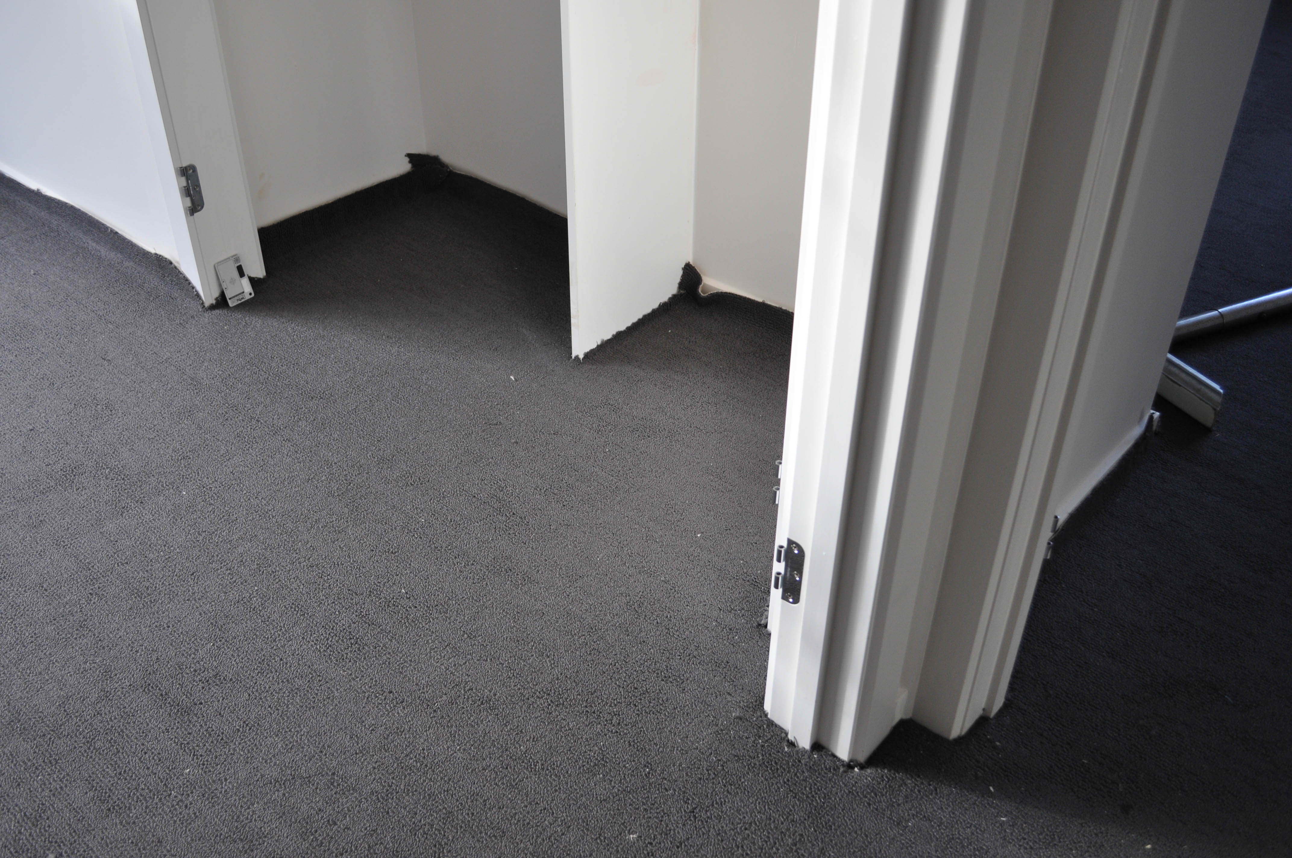 a room in a house in Werribee, where the carpet laying process is under way, where the carpet is laid out and stretched
 and the doors have been taken off to assist in the carpet laying process being done by Concord Floors.