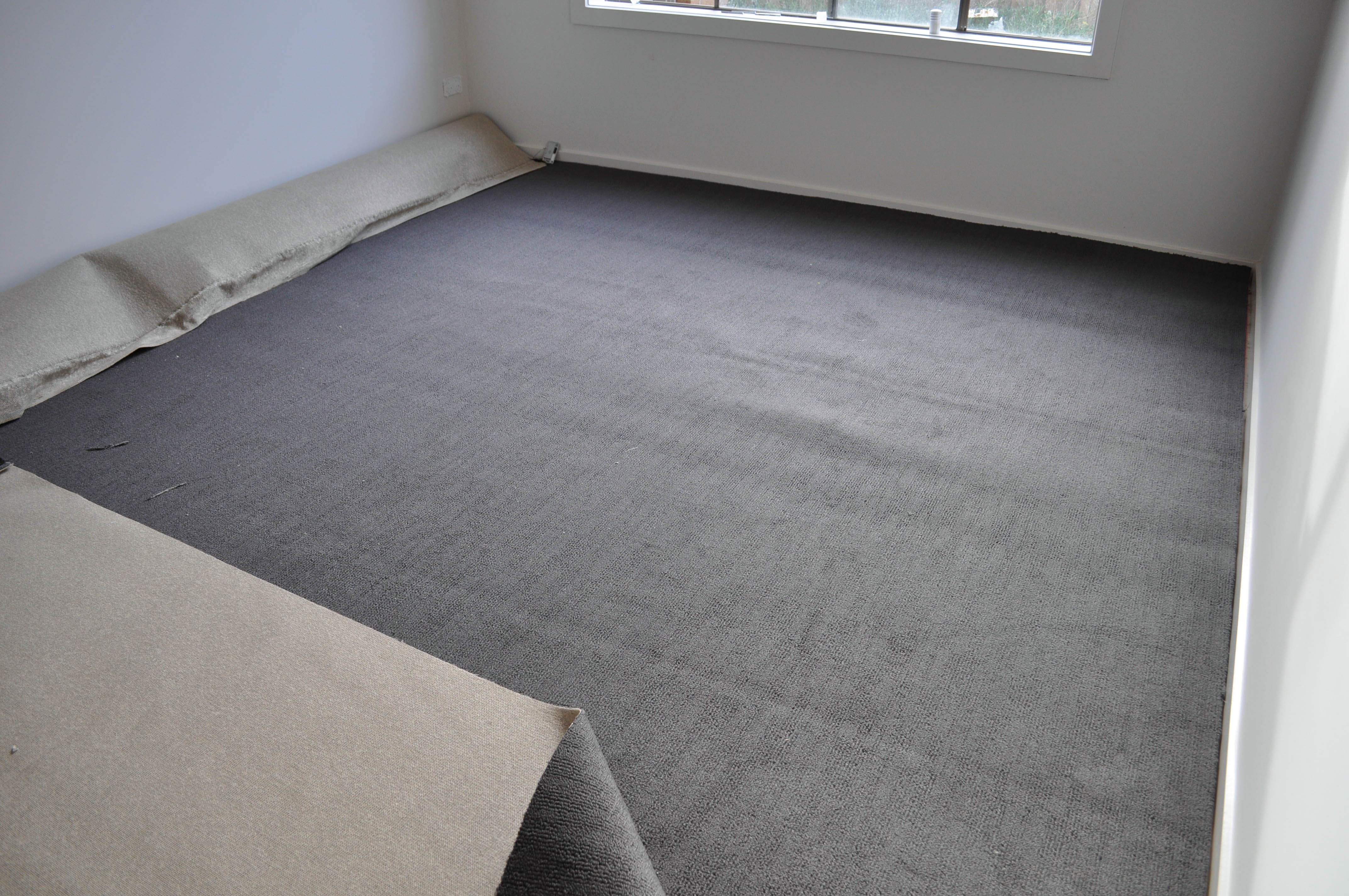 a roll of carpet that has been unrolled and positioned in a room ready for laying by Concord Floors, in a house 
 in Werribee, Vic 3030