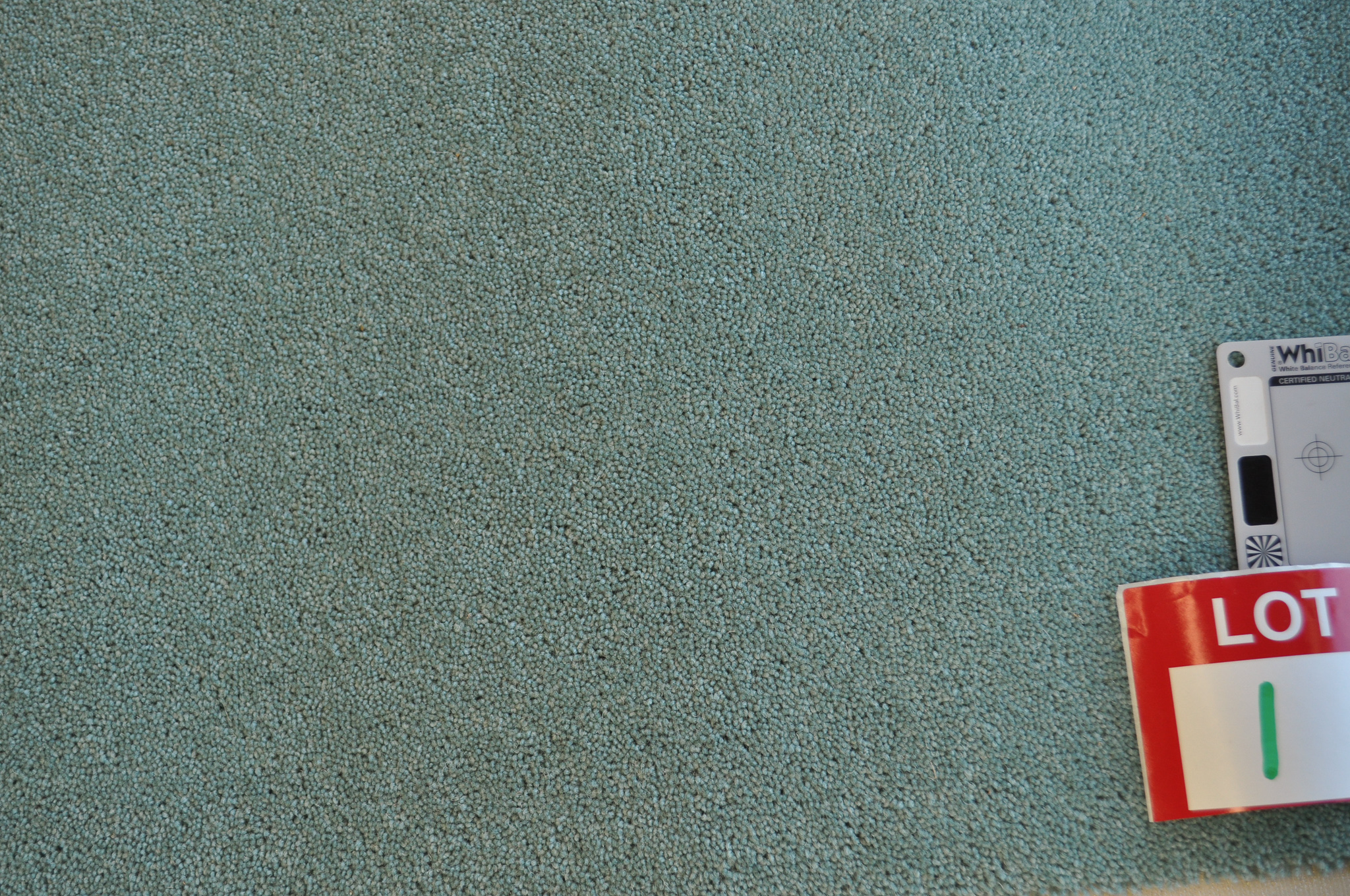 a sample of a wool/blend twist pile carpet, green color in a roll in the warehouse of Concord Floors and supplied
 to the public by Concord Floors.
