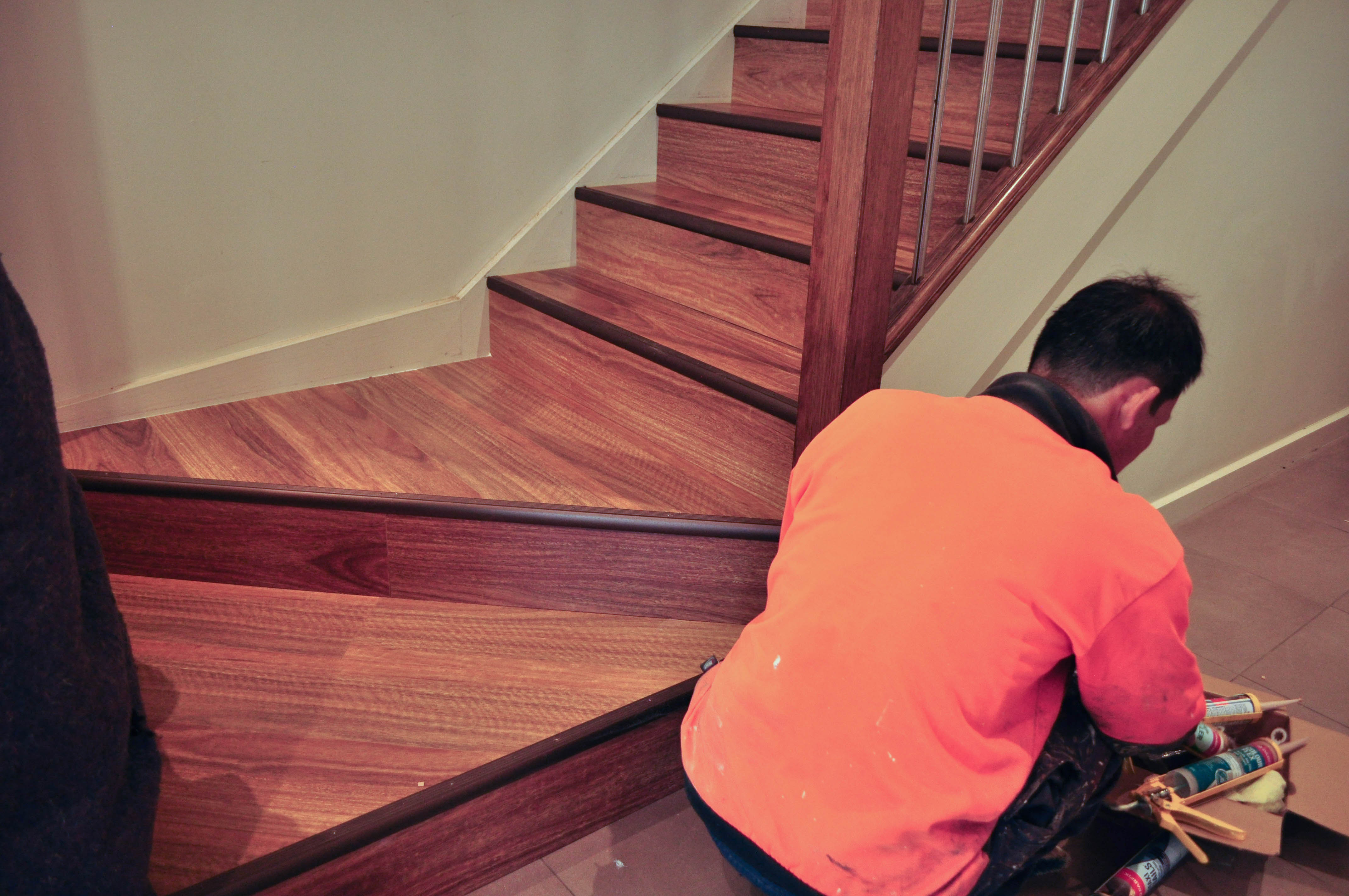 showing Concord Floor's laminate installer completing the installation of laminate flooring on a staircase.