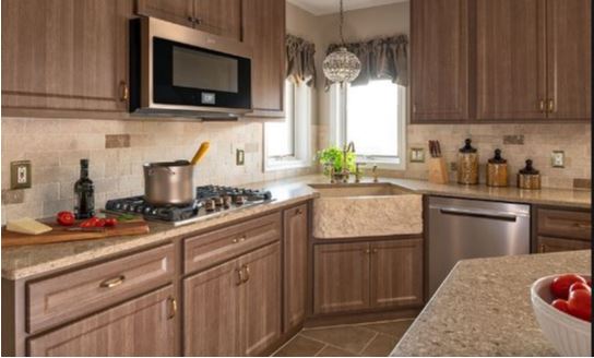 the picture shows a brown kitchen consisting of cabinets made from laminate floor board.