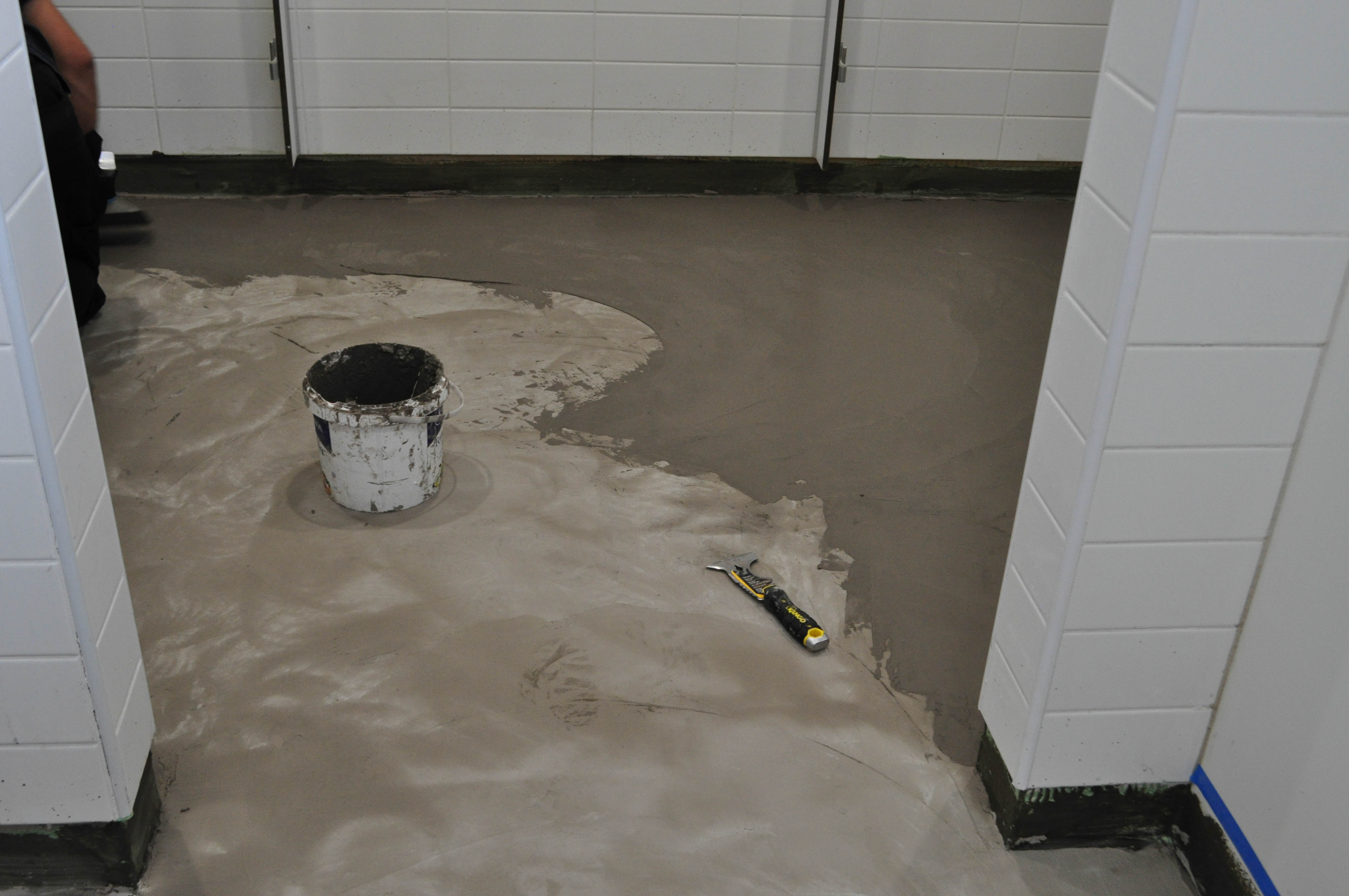 showing a toilet floor in a church that has had floor moisture barrier applied to it and now the floor leveller.