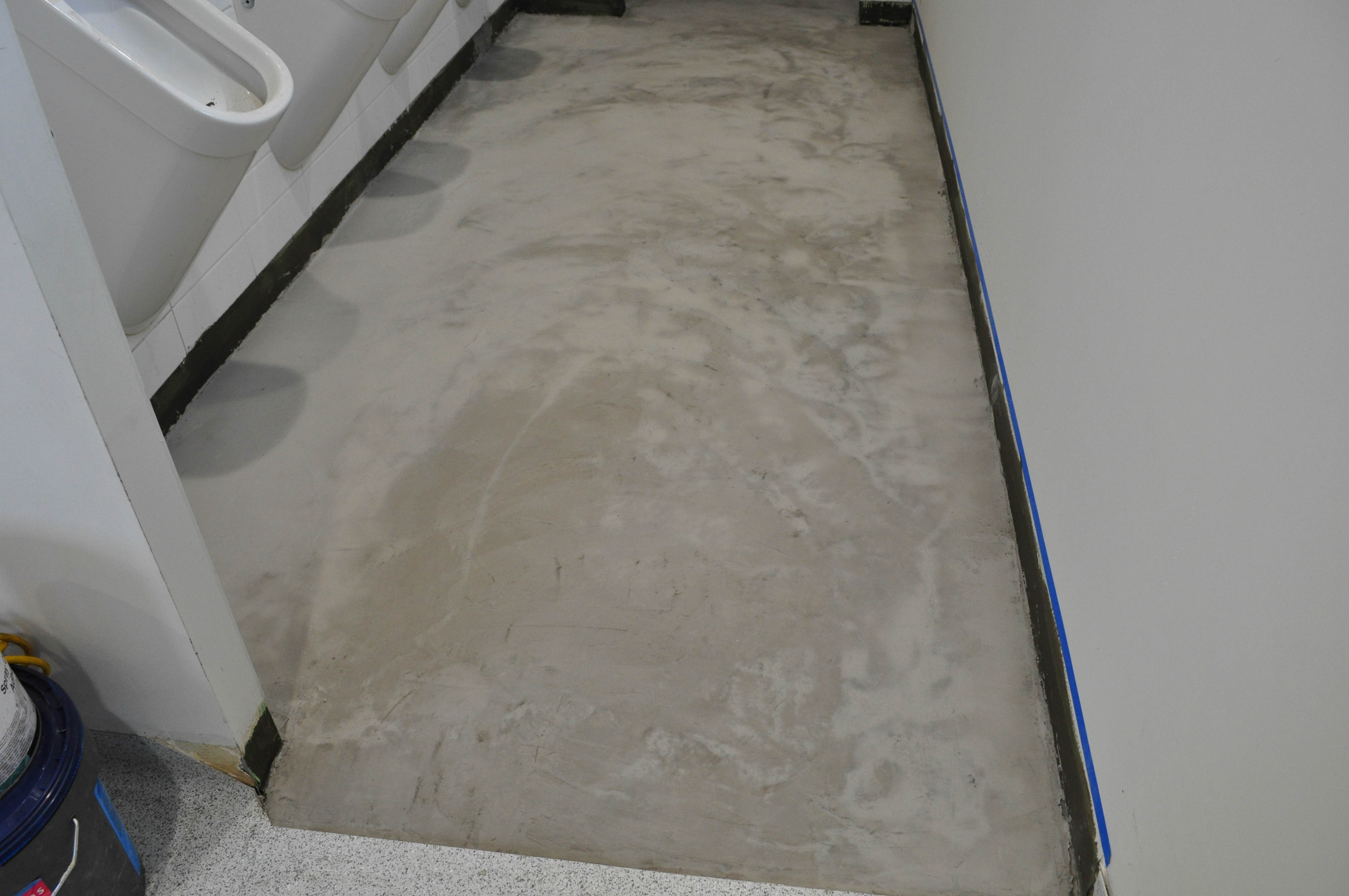 showing a toilet floor in a church that has had floor levelling compound applied to it.