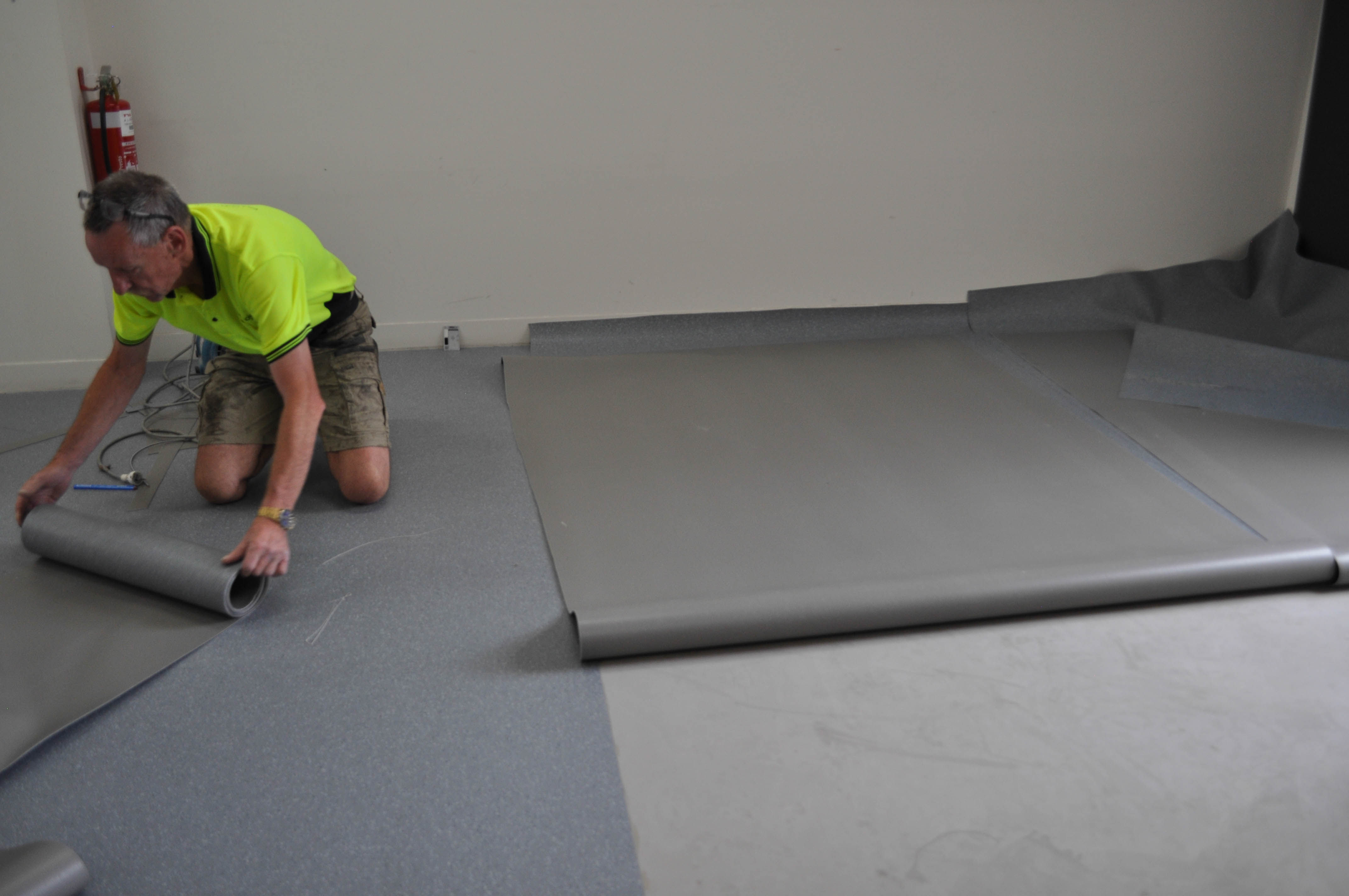 showing a kitchen where new light blue commercial vinyl flooring is being installed. This vinyl flooring is being installed by Concord Floors 
	in a real estate agency in Coburg.