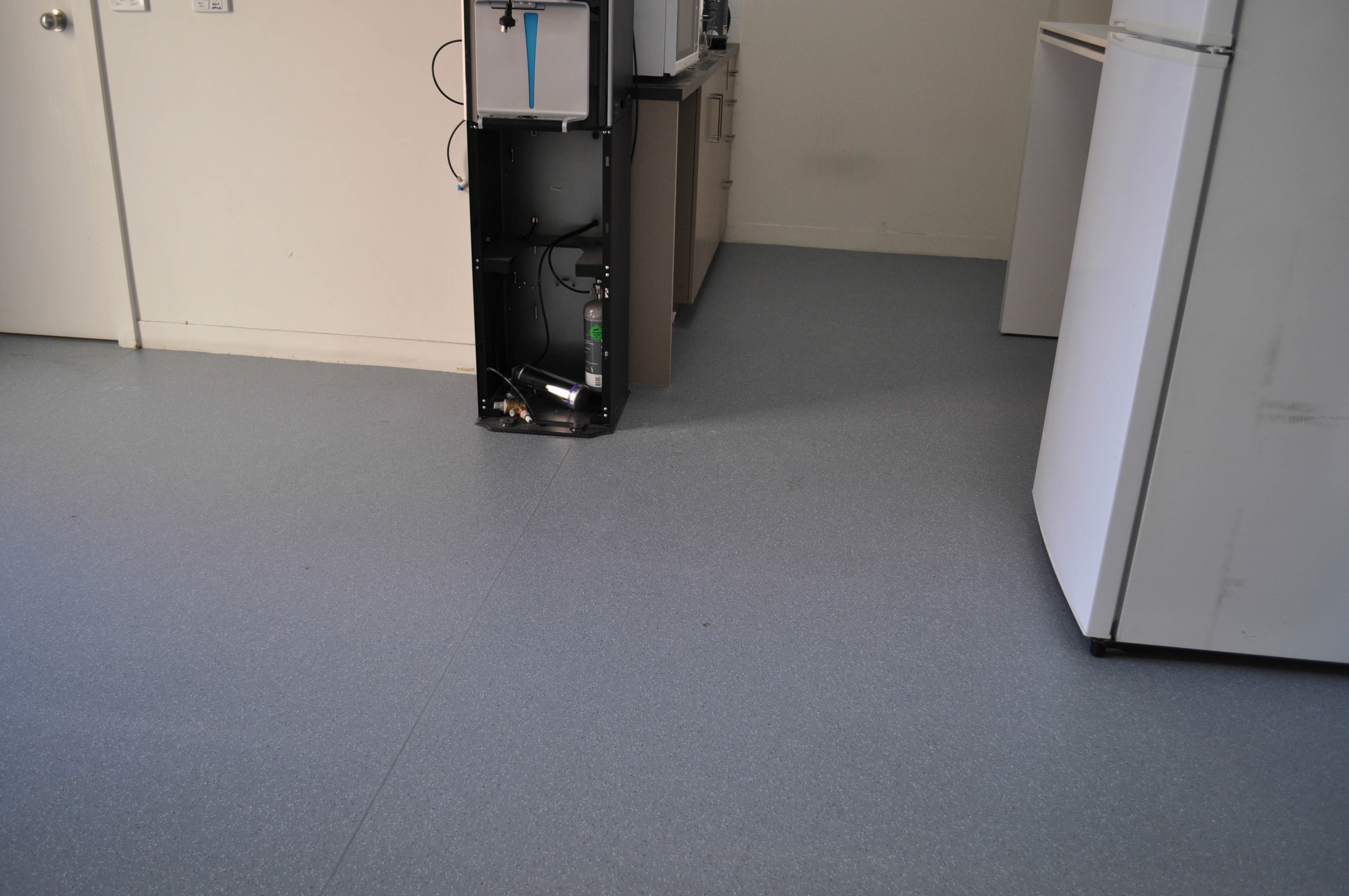 showing a kitchen with newly laid light blue commercial vinyl flooring. This vinyl flooring was installed by Concord Floors 
	in a real estate agency in Coburg.