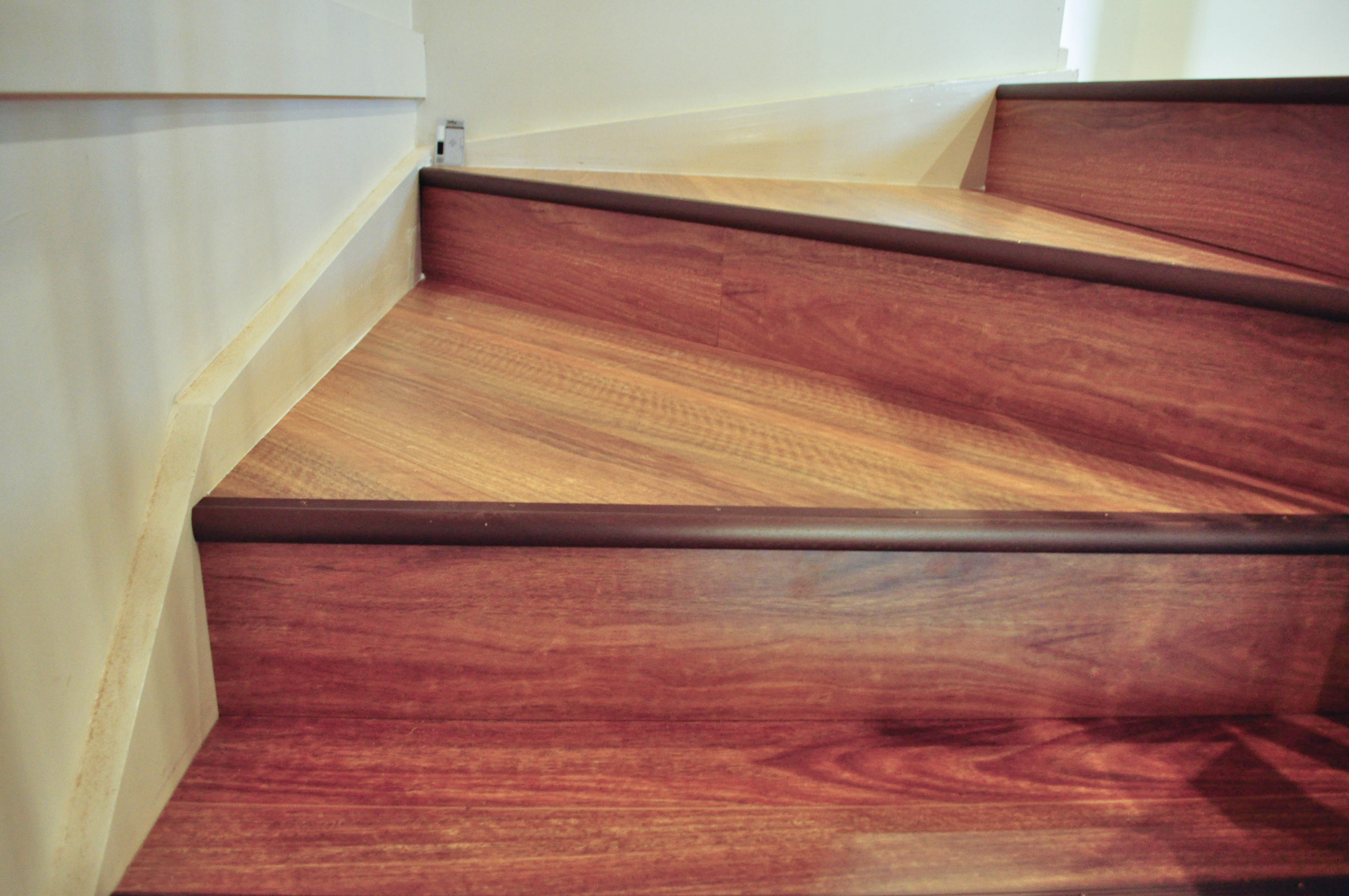 The laminate installation on a staircase done by Concord Floors. Showing 4 triangular steps of the staircase.