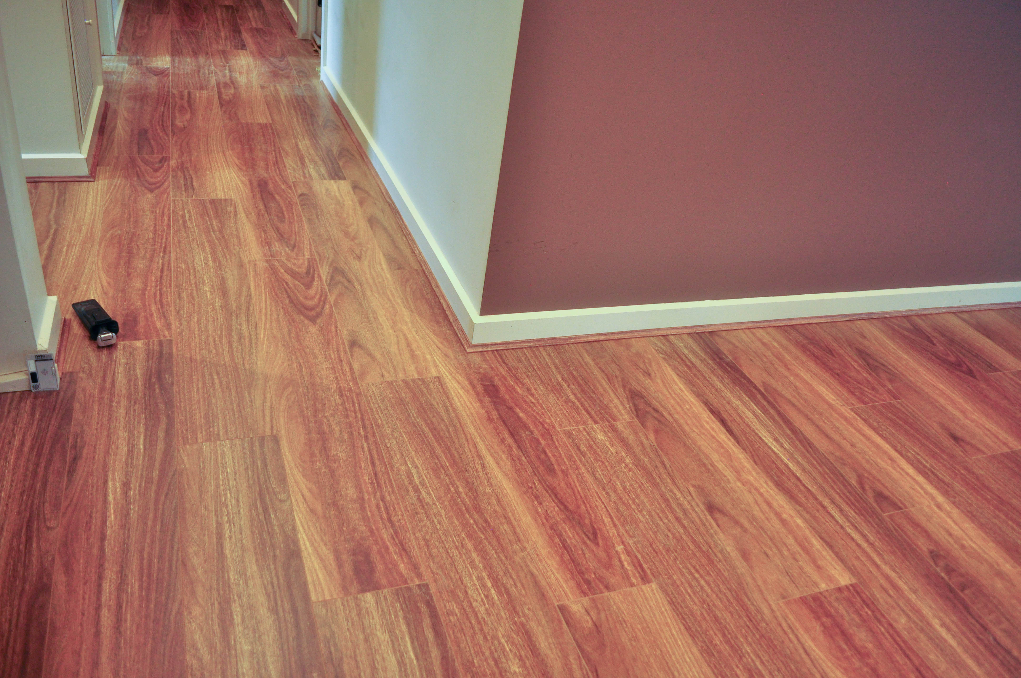 laminate flooring has been installed by Concord Floors in an empty room, in a home in Caroline Springs, that runs into an empty 
	  passage.