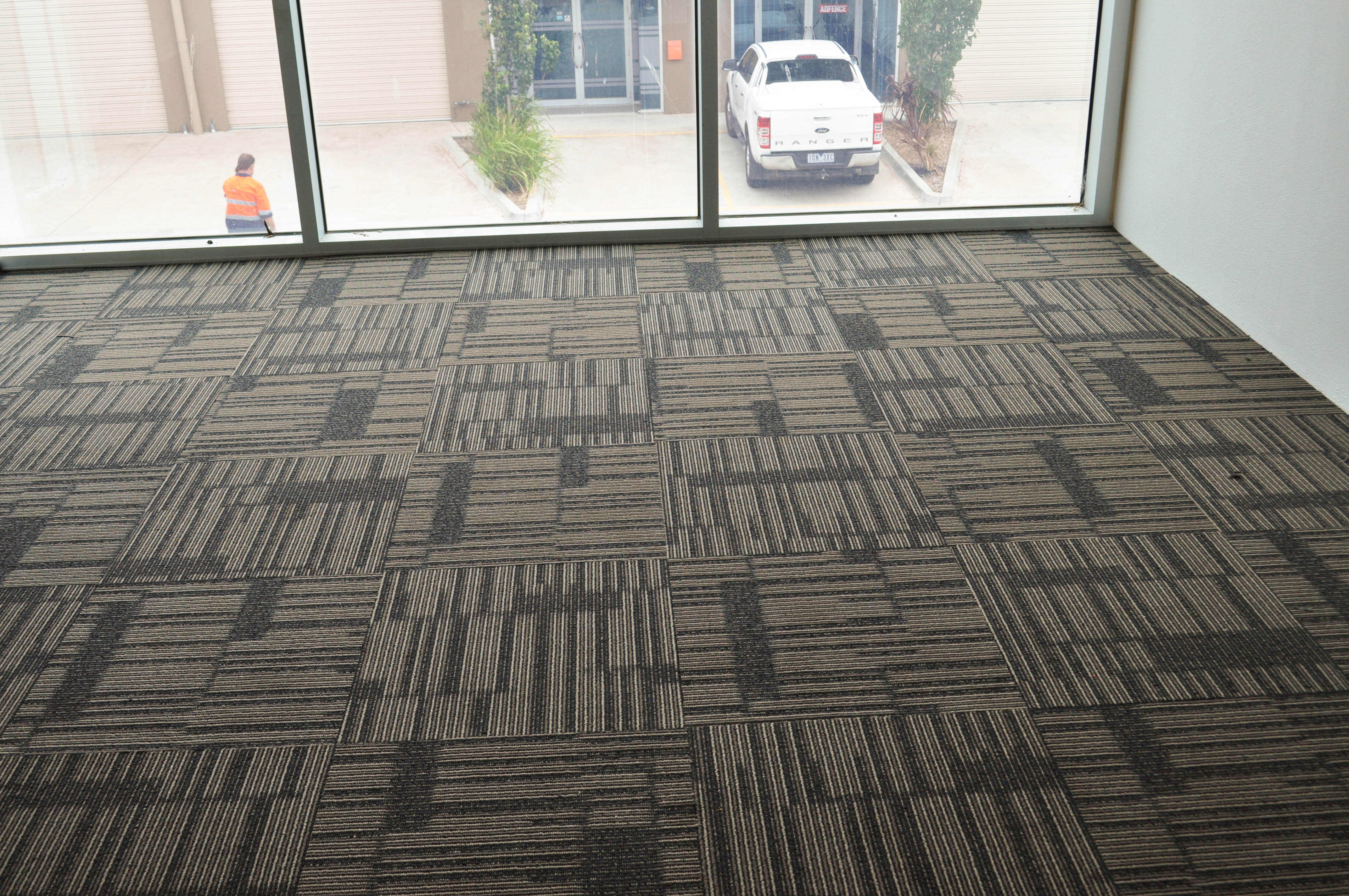 Showing a floor that has a patterned, beige carpet tile installed by Concord Floors on it. The building is in Derrimut.