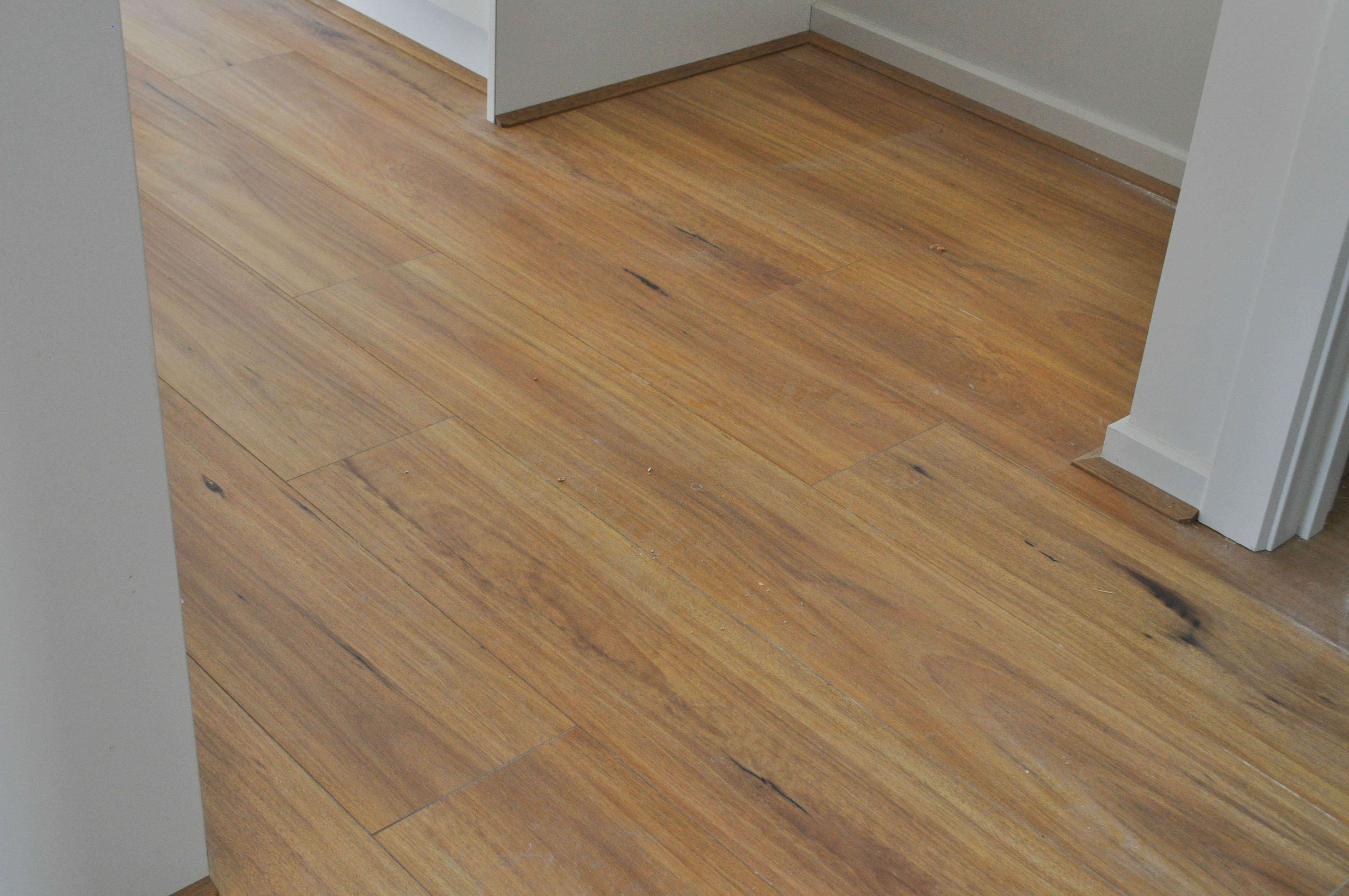 showing a kitchen inside a home where the floor has been floorboarded with cream colored laminate flooring.