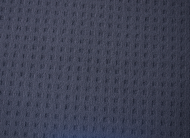 a sample of charcoal colored, polypropene fibre, loop pile, patterned carpet.