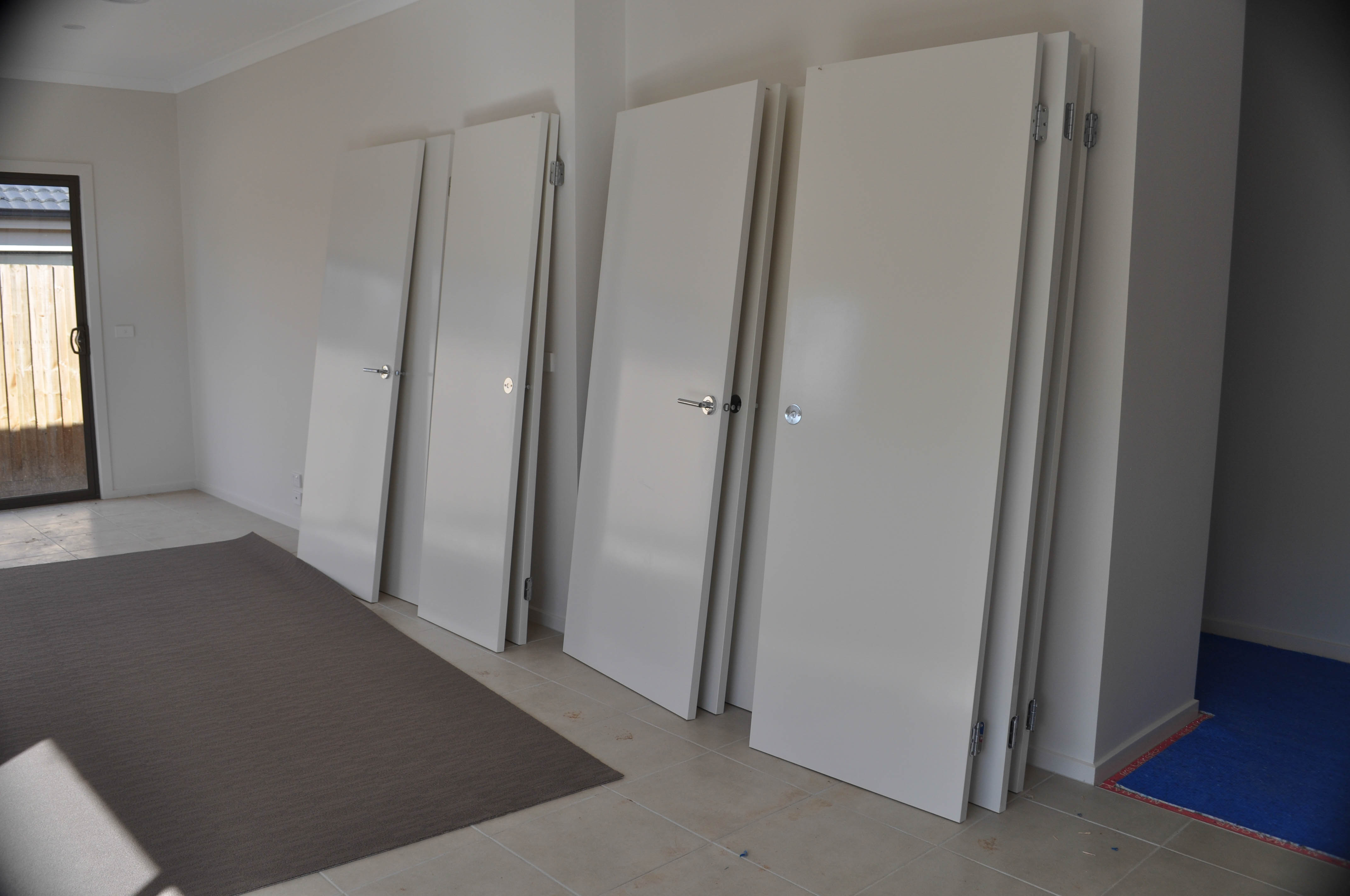 showing a dining room with 8 doors leaning against an upright wall waiting to be rehung upon completion of the carpeet installation process.
The home is in Hoppers Crossing, Melbourne, Victoria 3030, Australia