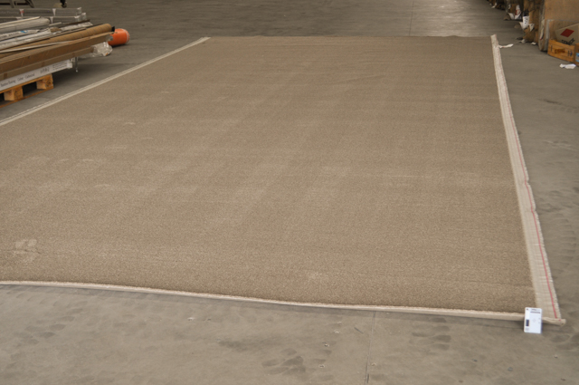 a beige slab of carpet laid out on the floor measuring 7.2 broadloom metres by 3.63 broadloom metres in Concord floor's carpet
 warehouse.