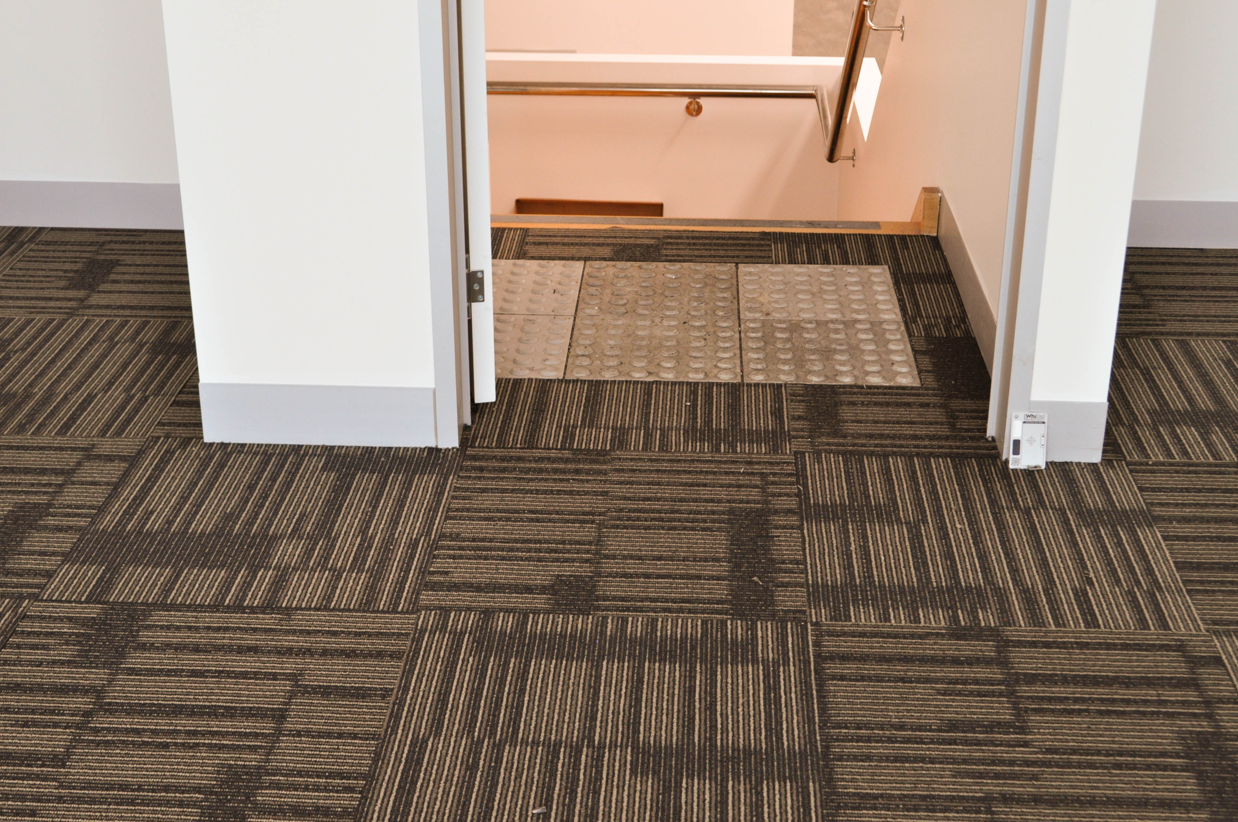 patterned, brown colored, square carpet tiles sold and installed by Concord Floors in a commercial property in 
Derrimut.