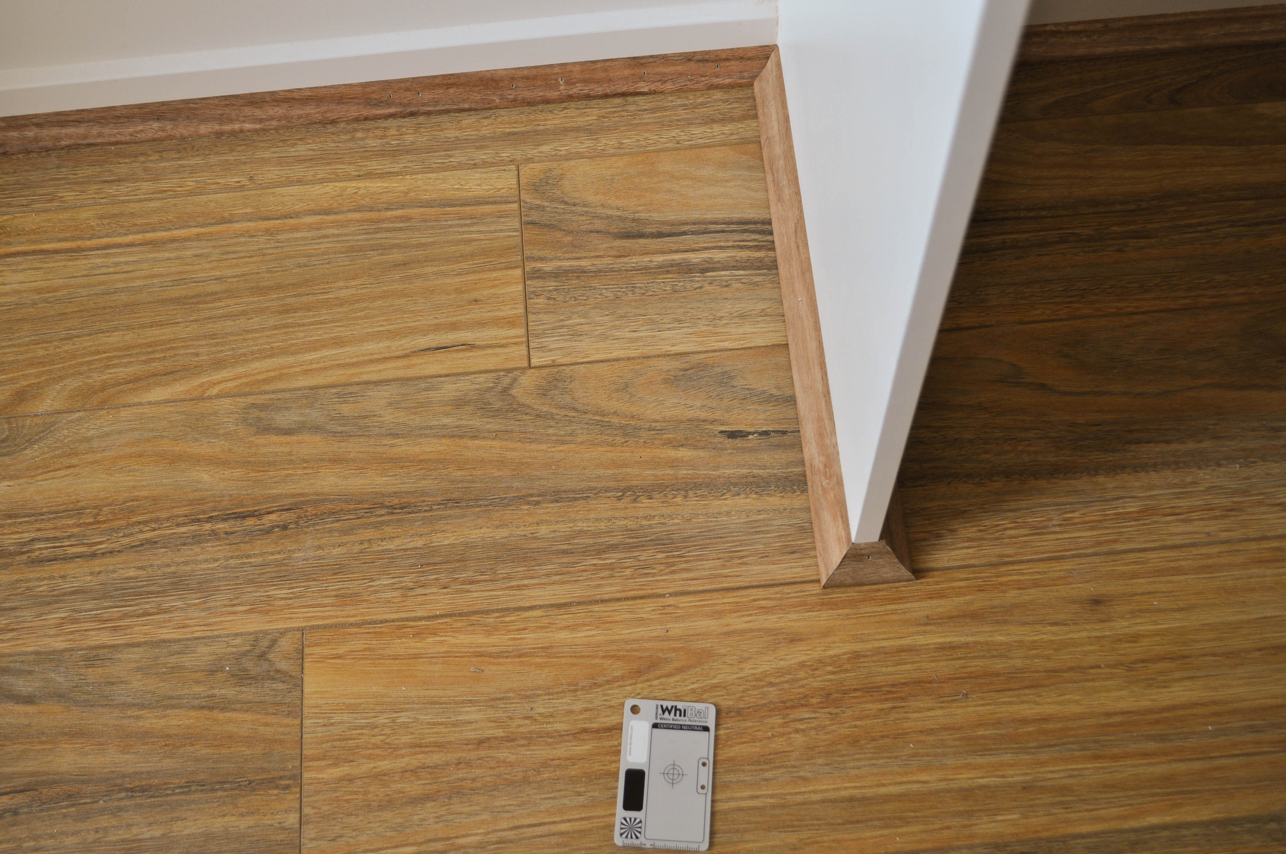 showing a walkin wardrobe floor where 12mm thick Spotted Gum,laminate floorboard flooring, having been installed in a wardrobe 
 and having the scotia that covers the expansion gap, fitted that has been cut to size and mitred at its ends. The picture shows how to mitre the ends for an elegant finish and how to 
 cover the 10mm expansion gap between the perimeter boundary of the aggregate floor and the perimter of the walls and fixed objects around which the floor boards need to go around. 
 The scotia has been fully nailed into place procing a very elgant and pleasing finish. The robe is in a home in Point Cook, Werribee Vic 3030. The installation was done by Concord
 Floors and the floor boards were supplied by Concord Floors.This is information as to how to install laminate flooring for the do it yourself floor board laminate flooring installer
 in the section on how to install the scotia that covers the 10mm expansion gap.