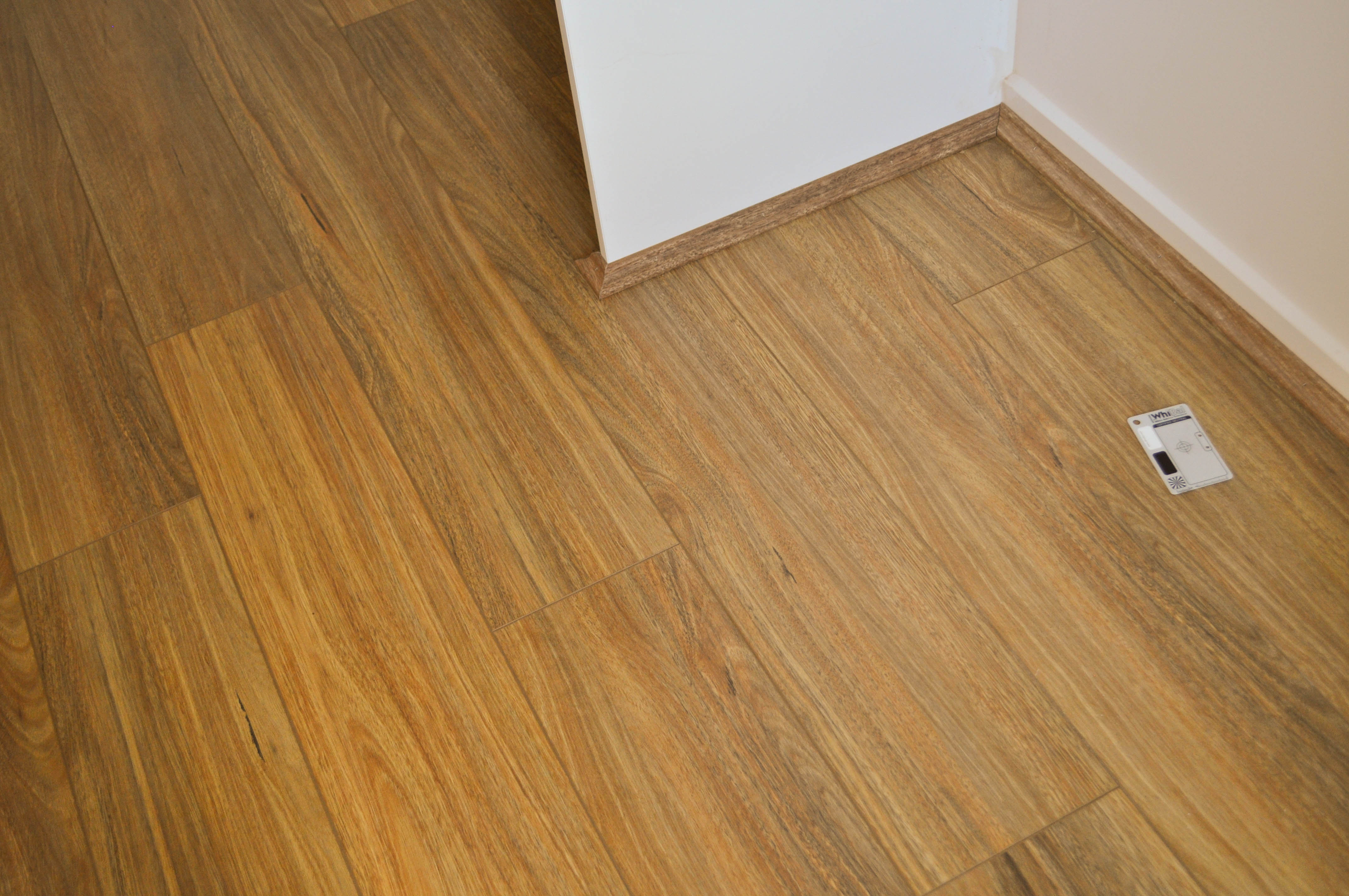 a photo of sample board of spotted gum, 12mm thick laminate flooring  board, of a particular brand (spotted gum g1) available to the
 public to buy Concord Floors and if they wish have it installed by Concord Floors.