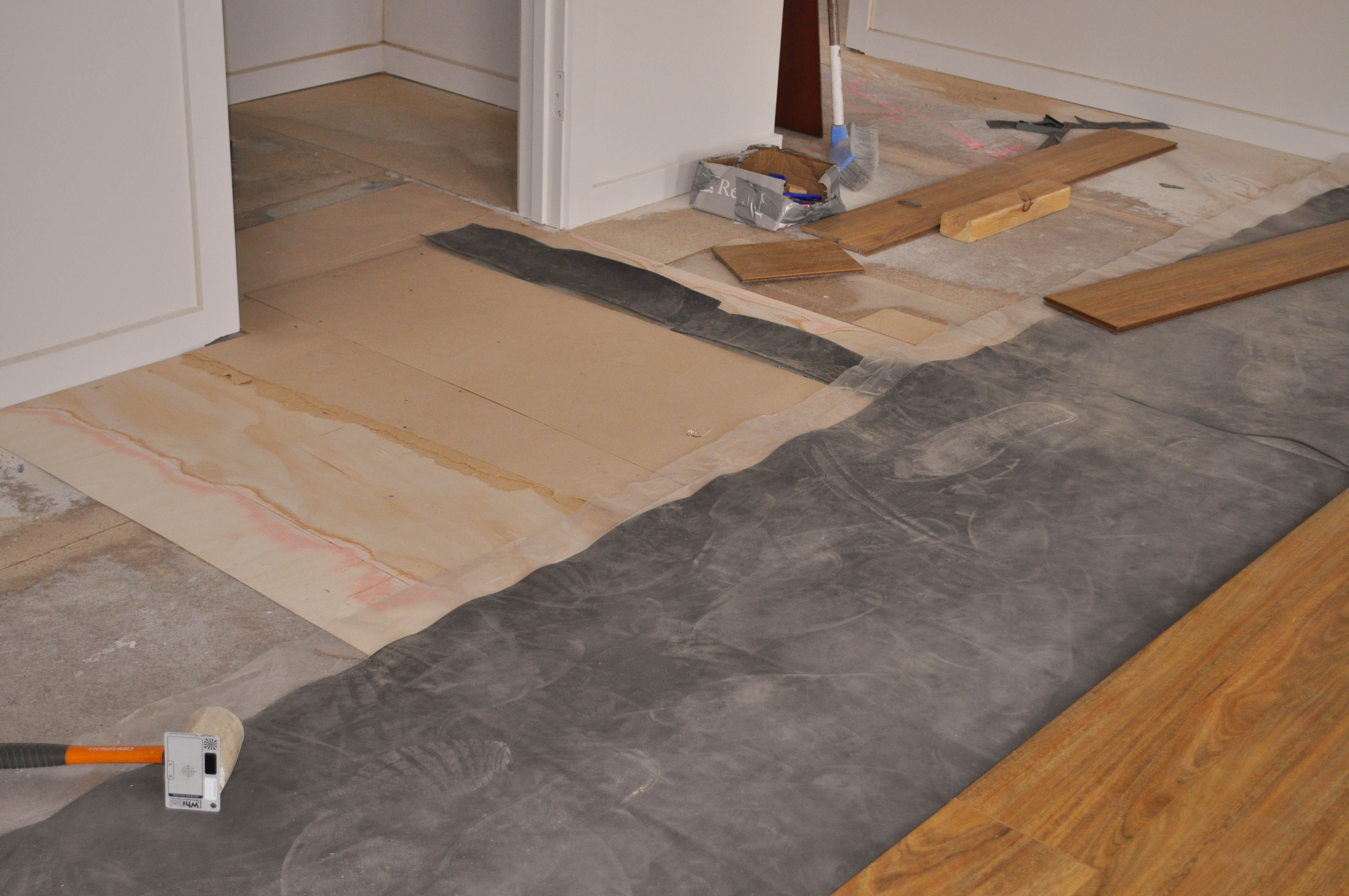 the picture is showing a particle board subfloor where levelling work has taken place. The low parts have been filled in with
  3mm thick plywood and the whole floor sanded to remove any imperfections. Following this the laminate undelay has been partially laid on top of which the 12mm thick spotted gum 
  floor boards have started to be laid.The laminate flooring was installed in a room in a house in the suburb of Werribee Vic 3340 by Concord Floors.