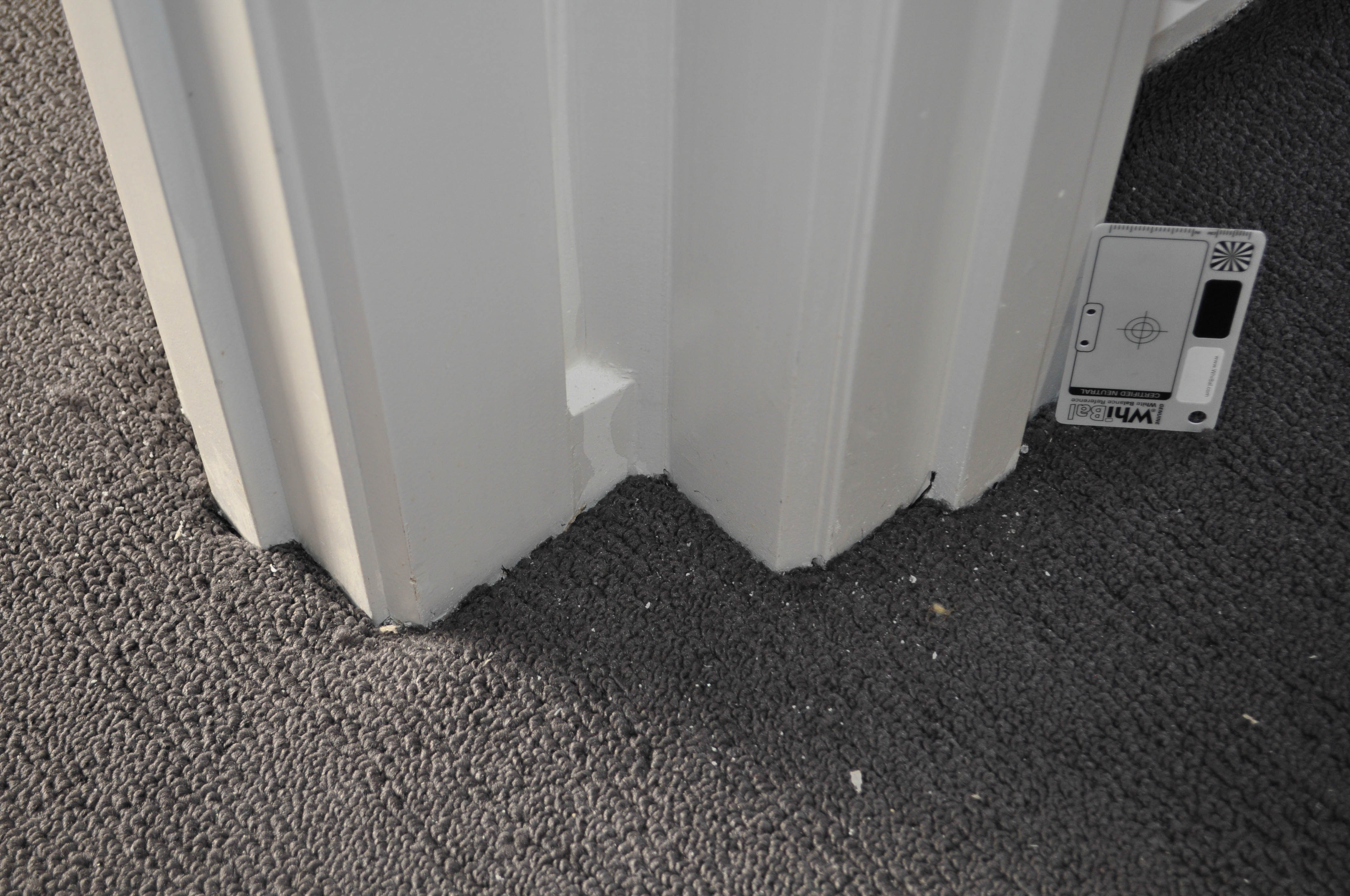 The picture shows the finished product of a section of laid carpet adjoining an inside corner created by doorway architraves
 that needed trimming and that can only be trimmed by a stanley knife that was trimmed and the carpet tucked into the crotch. The Carpet was being laid by Concord Floors in a house 
 Werribee, Vic, 3030.