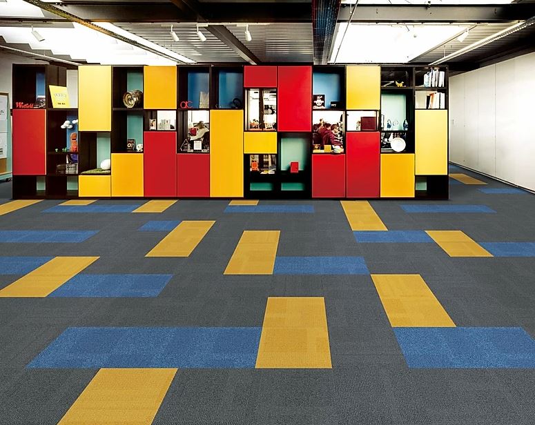 patterned, colorful carpet tiles in the color blue, yellow and grey of the PENTLAND range installed in a gallery on sale at Concord Floors.