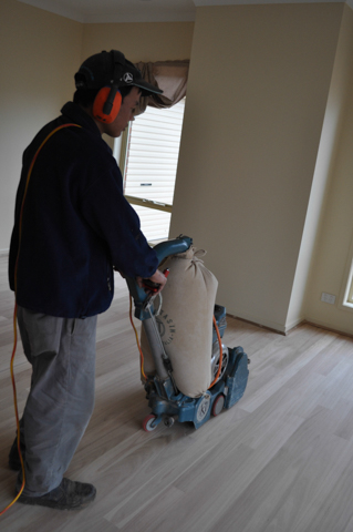 hardwood timber flooring being sanded after installation in a loungeroom