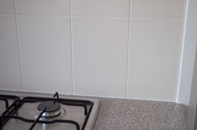 shows a kitchen benchtop and upright wall next to the benchtop where the ceramic wall tile installation process is complete, in Hoppers Crossing,
                 Melbourne, Victoria 3029, Australia