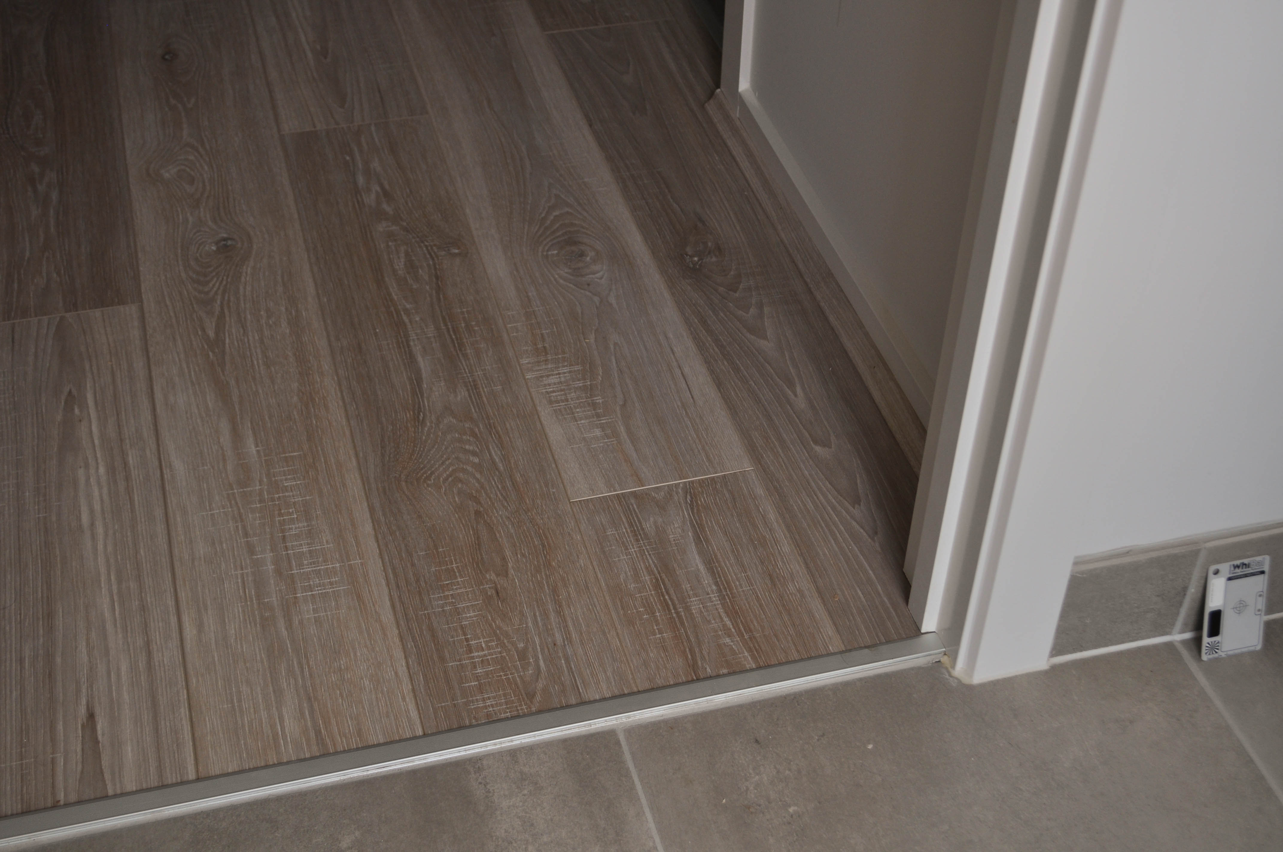 a passage floor in a residential home that is covered by laminate flooring which is a 12mm thick laminate floor, and it 
 abbutts to tile flooring in a laundry. the home is in the suburb of Hoppers Crossing Vic 3029 aand the laminate flooring was installed  by Concord Floors who also supplied
 the floor.
