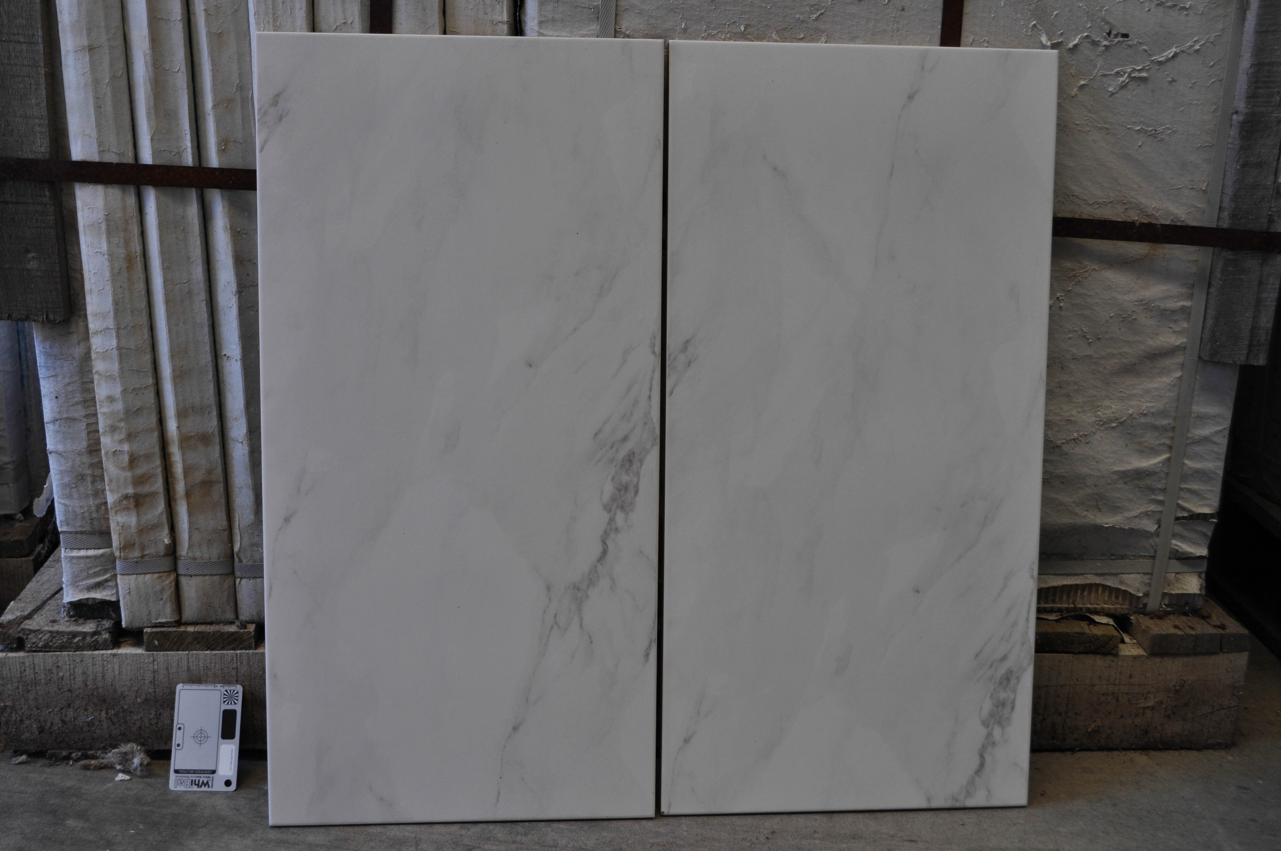 a sales sample of a 30cm x 60cm porcelain tile, with a white marble look, available for purchase from Concord
             Floors